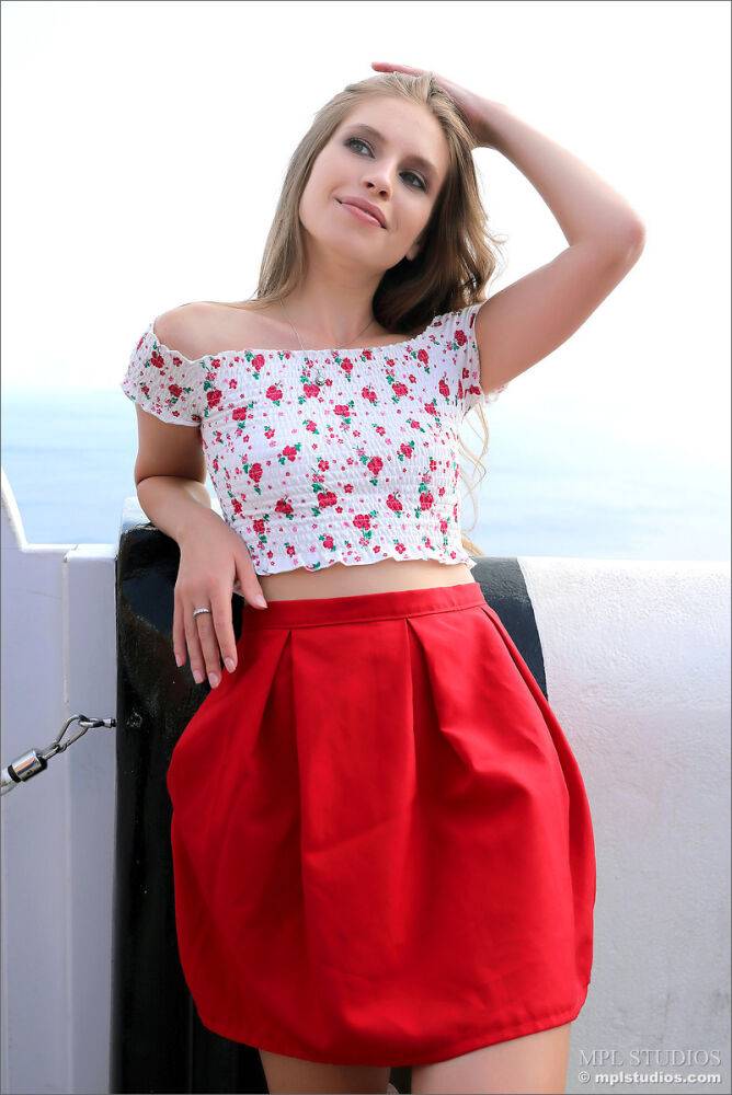 Pretty girl models fully clothed in a red skirt while on vacation - #2