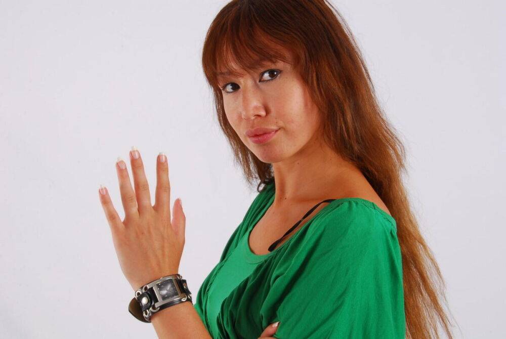 Redheaded Asian girl Evita models a Guess style cuff watch during SFW action - #16