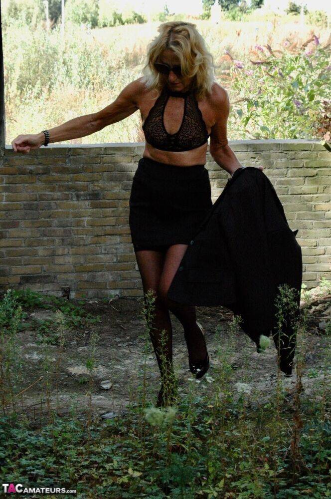 Mature blonde Kyras Nylons models stiletto heels in hosiery and a black skirt - #11