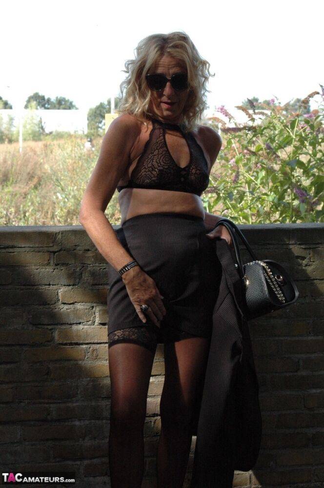 Mature blonde Kyras Nylons models stiletto heels in hosiery and a black skirt - #5