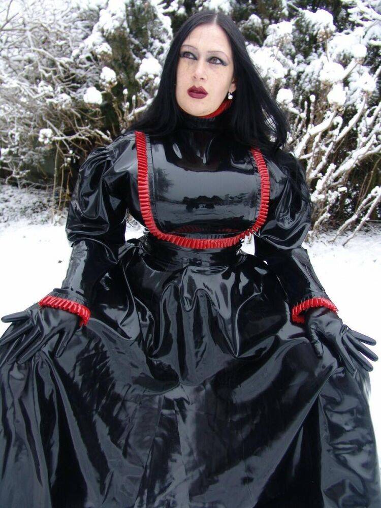 Goth woman Lady Angelina models a black latex dress on snow-covered ground - #13