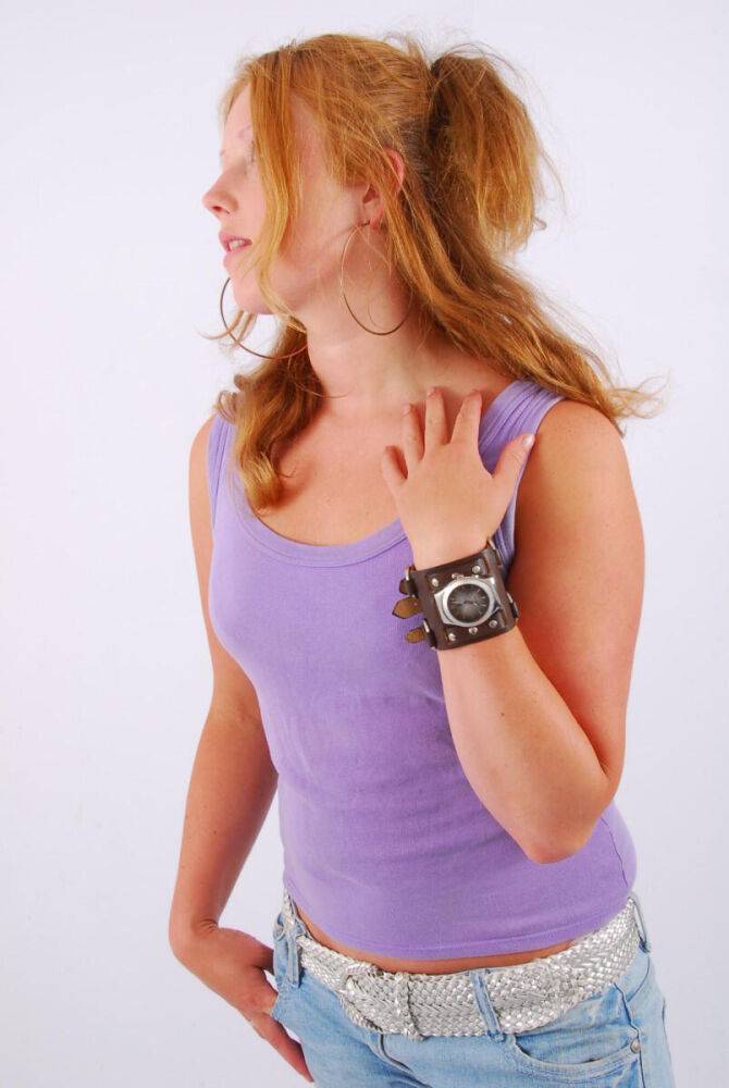 Natural redhead models a large cuff watch in a tank top and faded jeans - #8