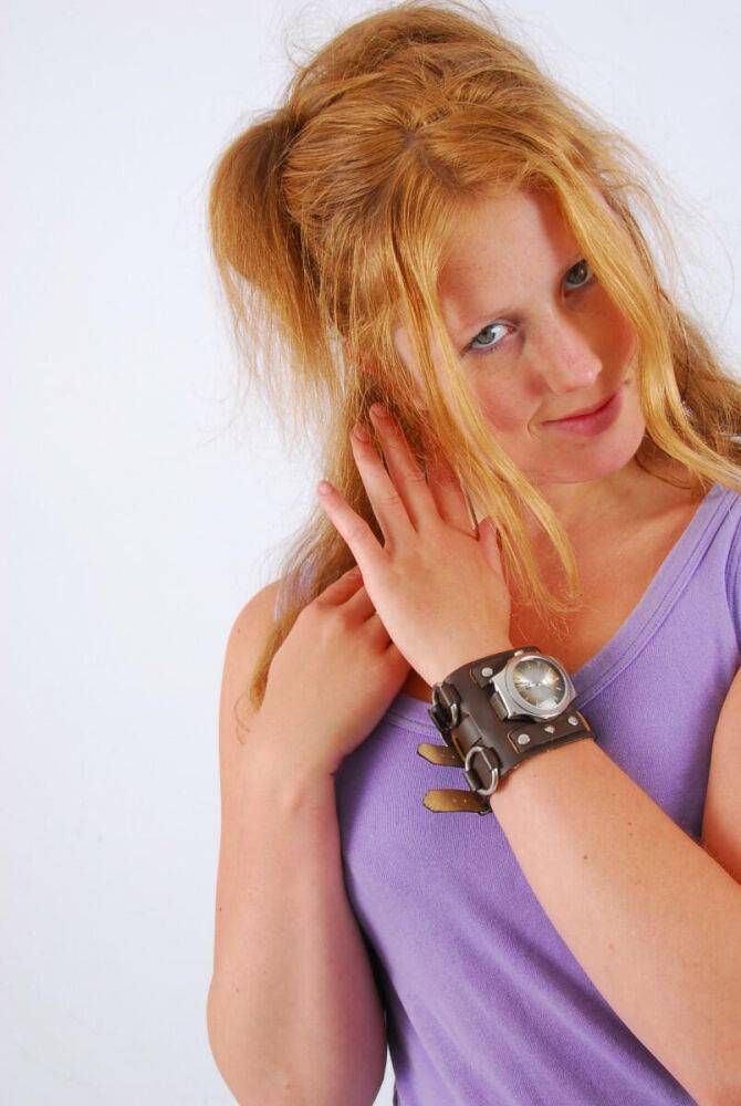 Natural redhead models a large cuff watch in a tank top and faded jeans - #15