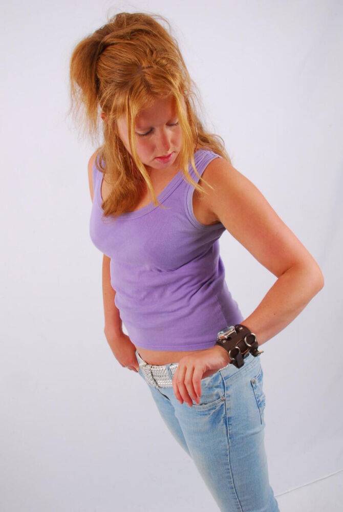 Natural redhead models a large cuff watch in a tank top and faded jeans - #14