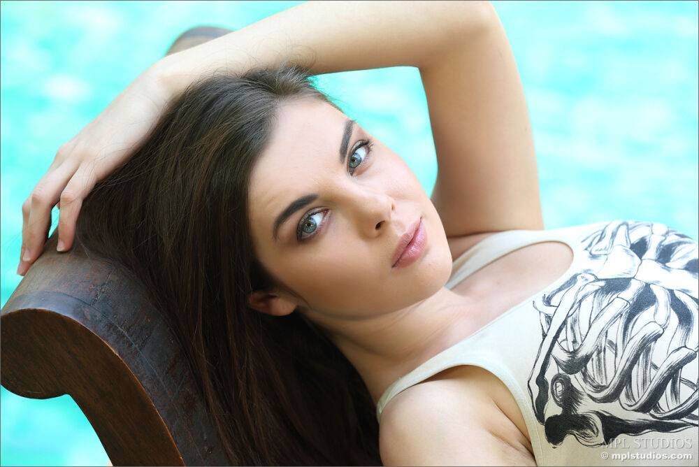 Beautiful girl models totally naked on a bench near a swimming pool - #8