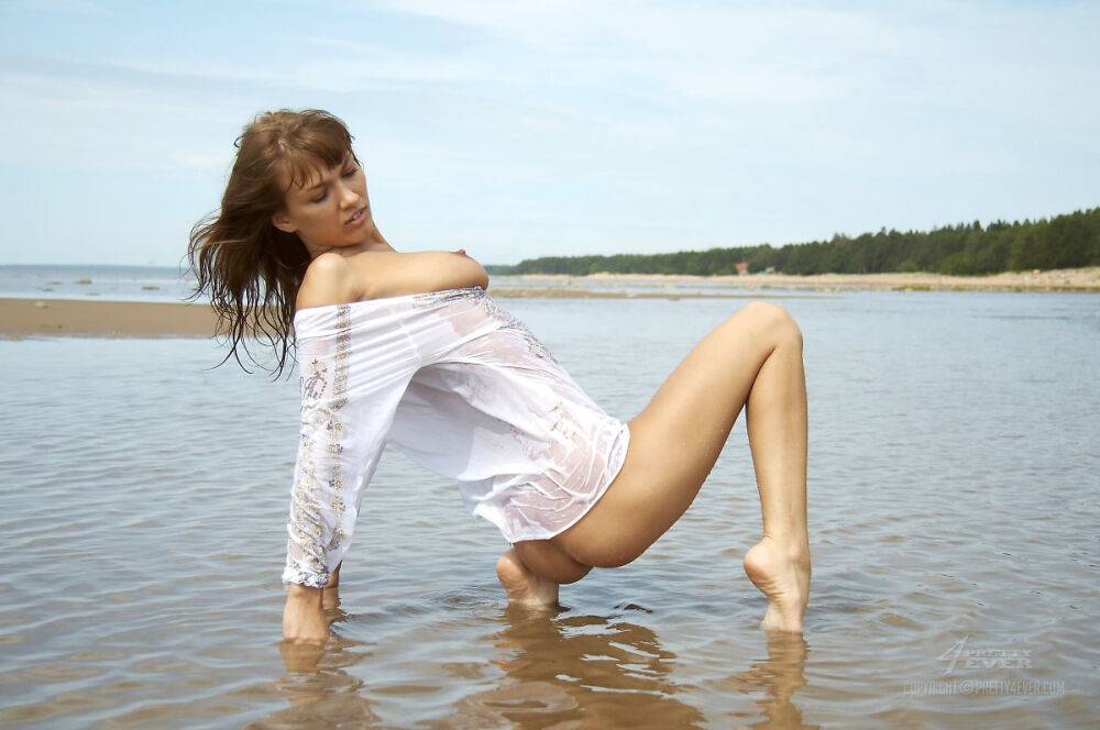 Young beauty Alena models in shallow water during solo action - #13