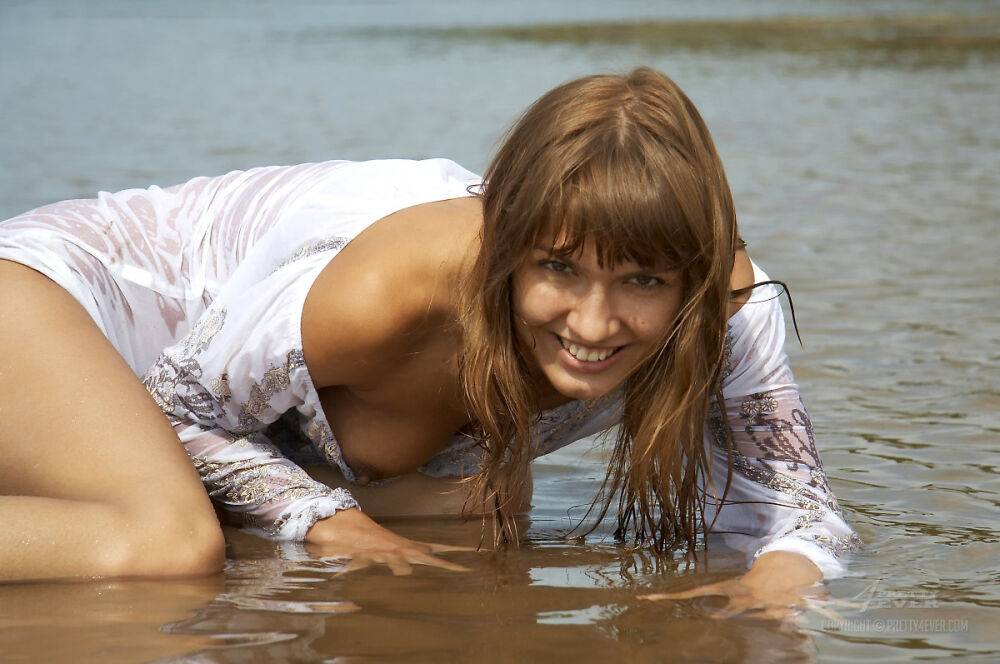 Young beauty Alena models in shallow water during solo action - #10