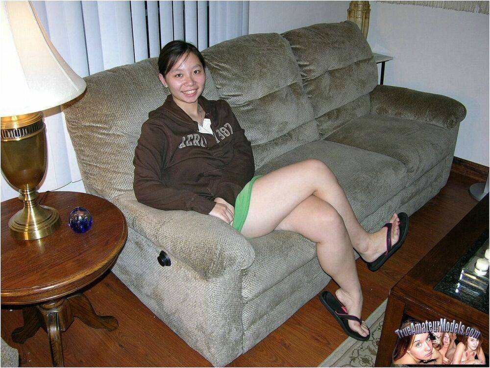 Barely legal Asian girl wears nothing more than a smile while showing her twat - #12