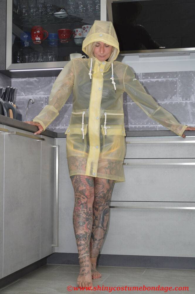 Tattooed blonde Miss Francine models barefoot in a raincoat over rubber wear - #9