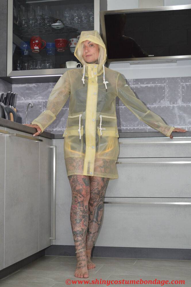 Tattooed blonde Miss Francine models barefoot in a raincoat over rubber wear - #13