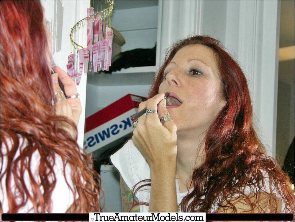 Redheaded girl does her lips in a mirror before getting naked in black boots - #4