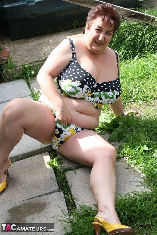 Thick older woman Kinky Carol models a bikini on patio stones - #13