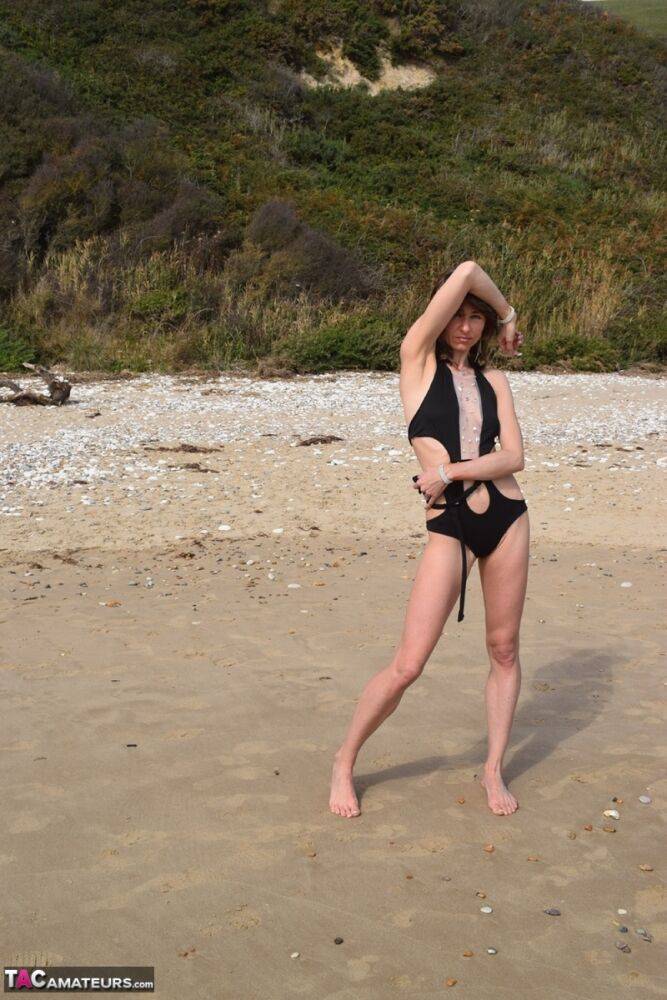 Slender female models a bathing suit while at a deserted beach - #8