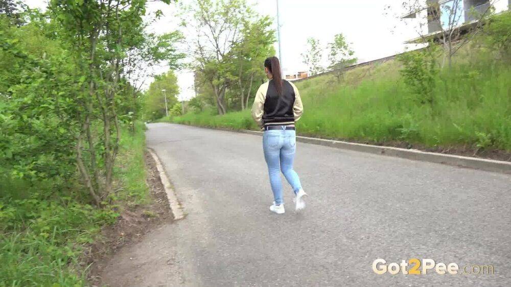 Clothed girl pulls down ripped jeans for a pee while bicyclists pass by her - #1