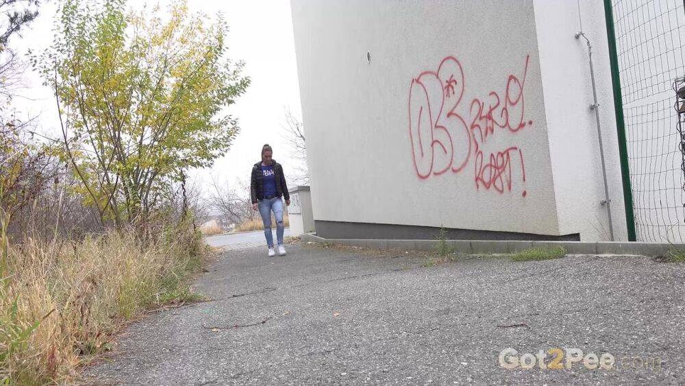 Czechoslovakian female Naomi Bennet takes a pee on pavement beside a building - #15