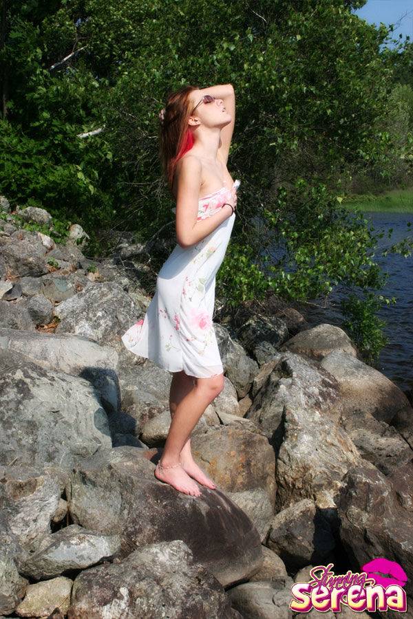 Young redhead Stunning Serena slips out of her dress on waterside rocks - #8