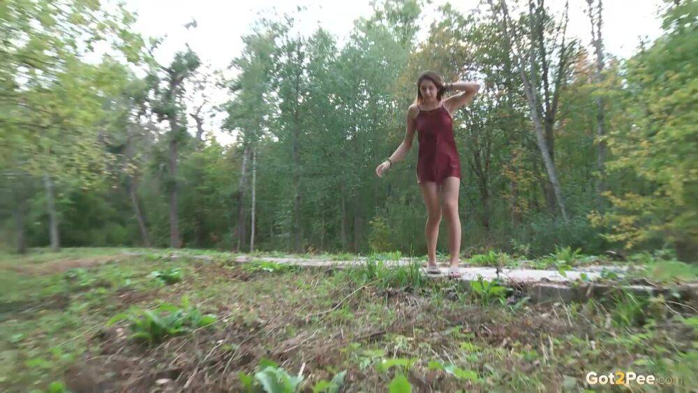 Leggy girl Diana Sweet places a foot against a tree for a piss in the woods - #11