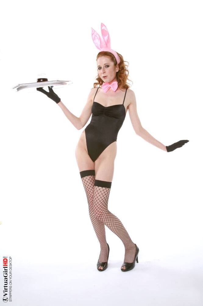 Natural redhead Lucie T holds a drink tray while stripping to fishnets - #7