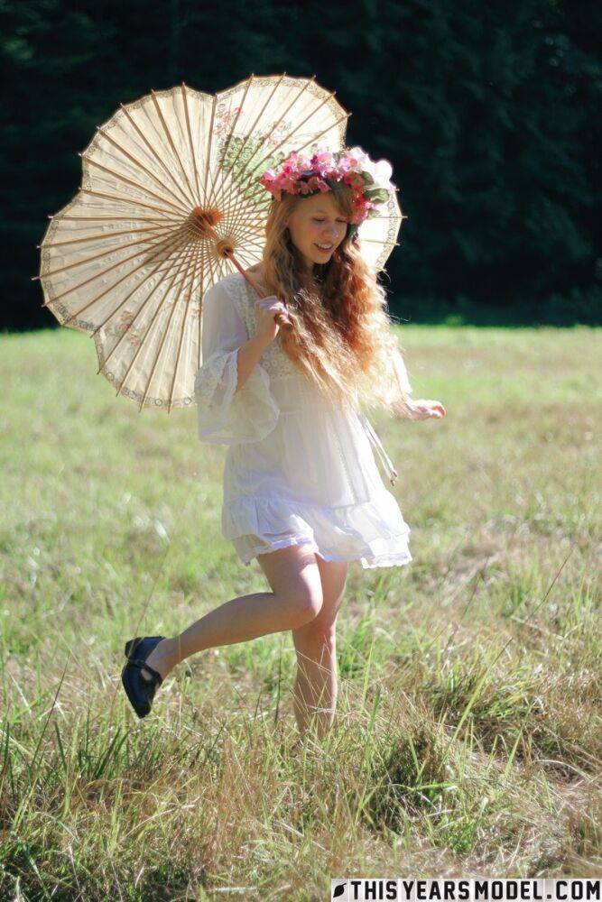 Charming redheaded teen Dolly Little holds a parasol while getting naked - #6