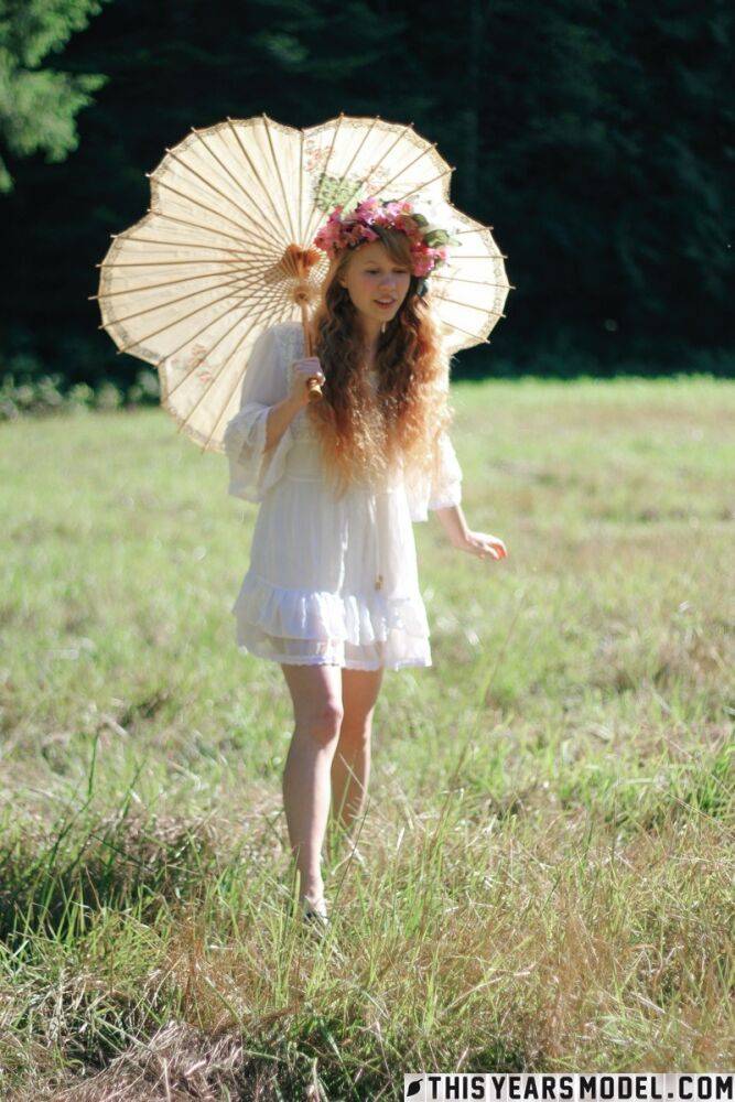 Charming redheaded teen Dolly Little holds a parasol while getting naked - #2