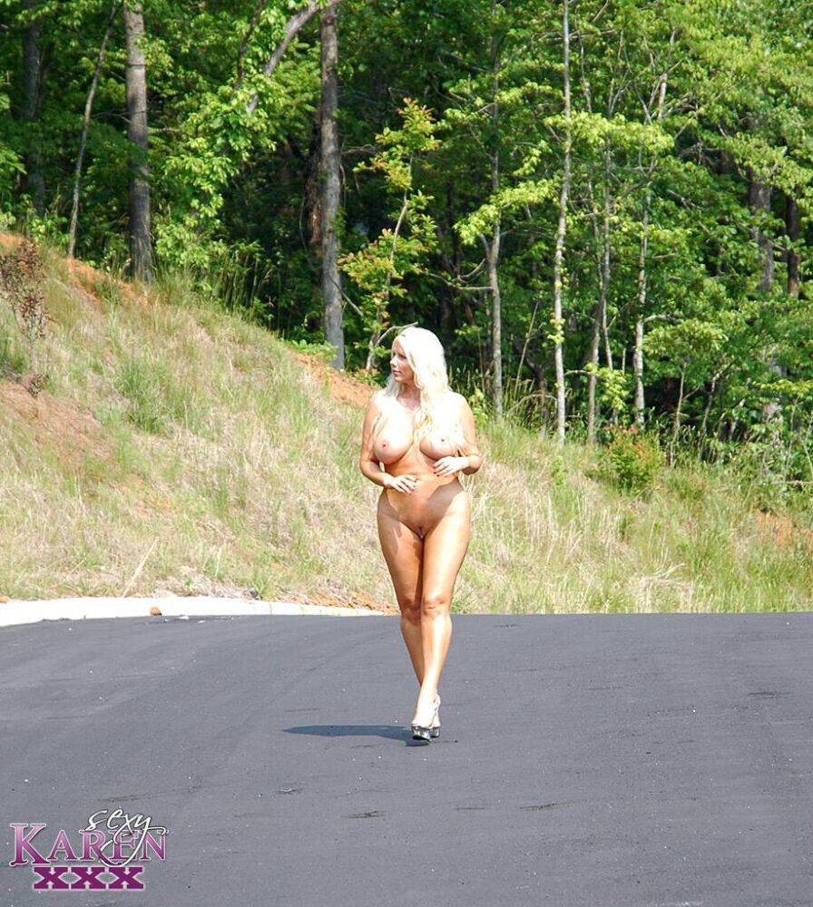 Busty blonde Karen Fisher wanders a paved road while naked before masturbating - #10