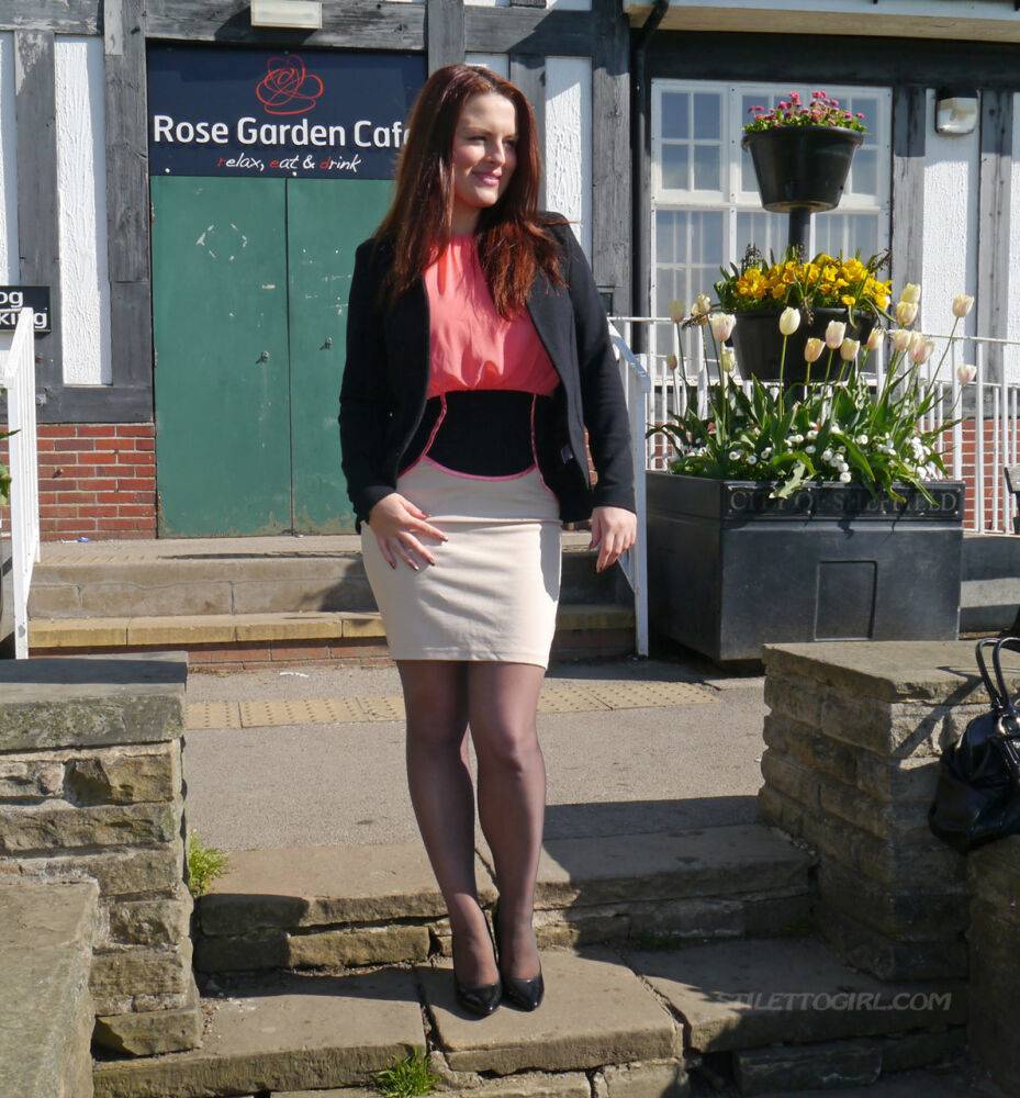 Clothed redhead Sara shows off her black heels on a sidewalk in hosiery - #9