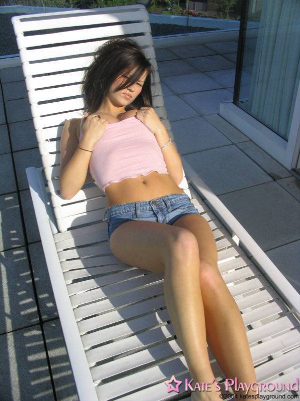 Hot teen brunette in shorts suns long legs & round big boobs on a deck chair - #4