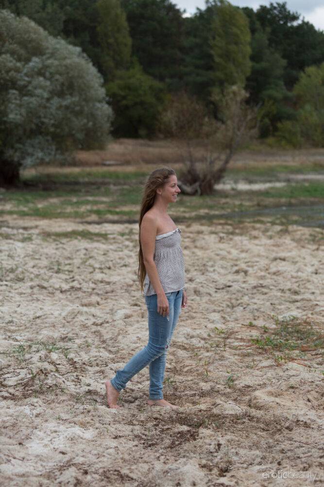 Teen model Mika A works free of faded blue jeans to get naked on a beach - #11