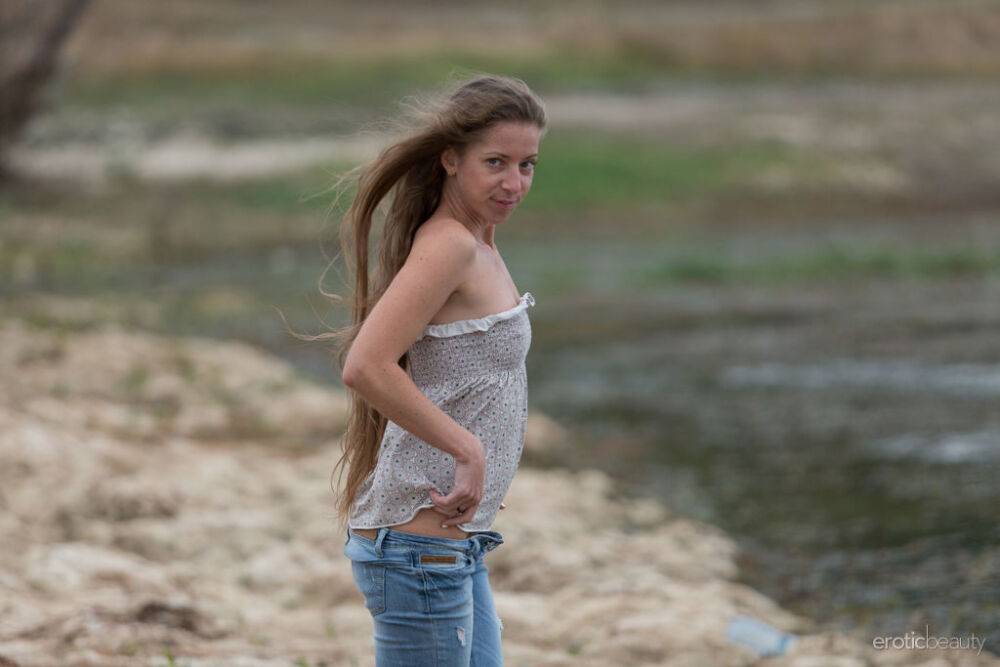 Teen model Mika A works free of faded blue jeans to get naked on a beach - #14