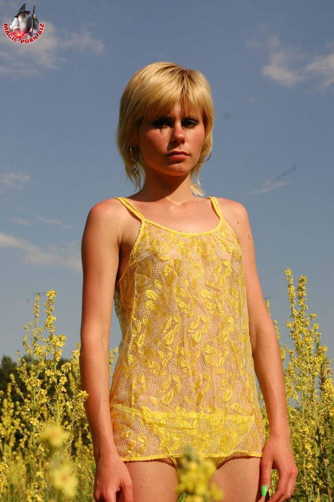 Young looking blonde girl shows her skinny body amid blooming wild flowers - #2