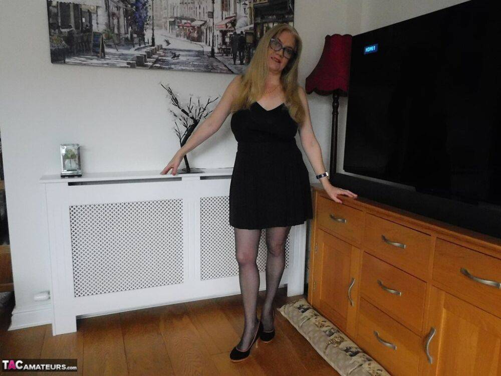 British woman Lily May uncovers her large breasts near a big screen TV - #11