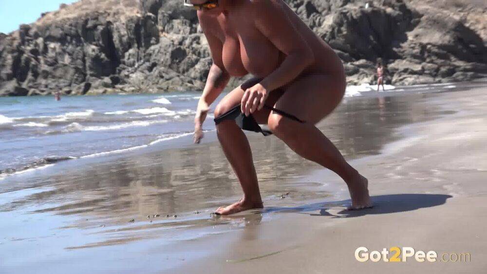 Big titted woman Chloe Lamour squats for a pee while walking on a beach - #1