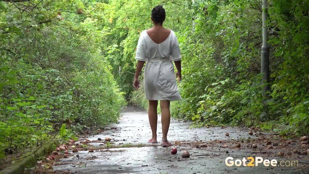 Solo female Chloe Lamour takes a piss on a paved path while wearing sandals - #1