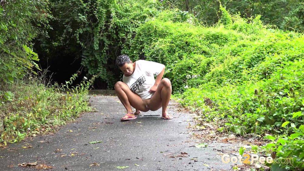 Solo female Chloe Lamour takes a piss on a paved path while wearing sandals - #13