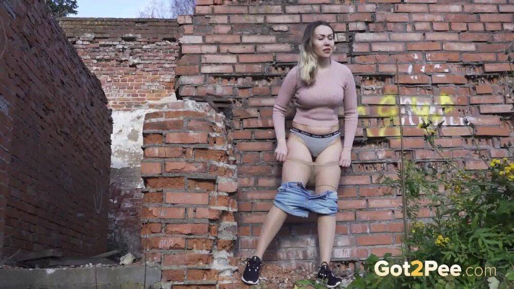 White girl ducks behind an old building to take an urgent piss - #10