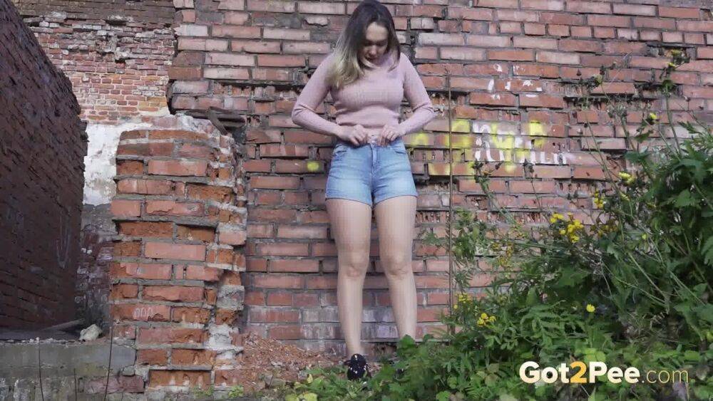 White girl ducks behind an old building to take an urgent piss - #7