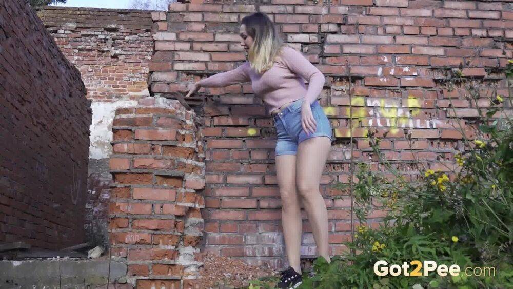 White girl ducks behind an old building to take an urgent piss - #5