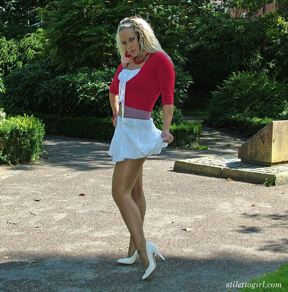 Blonde solo model shows off her white pumps in hose and skirt on pavement - #16