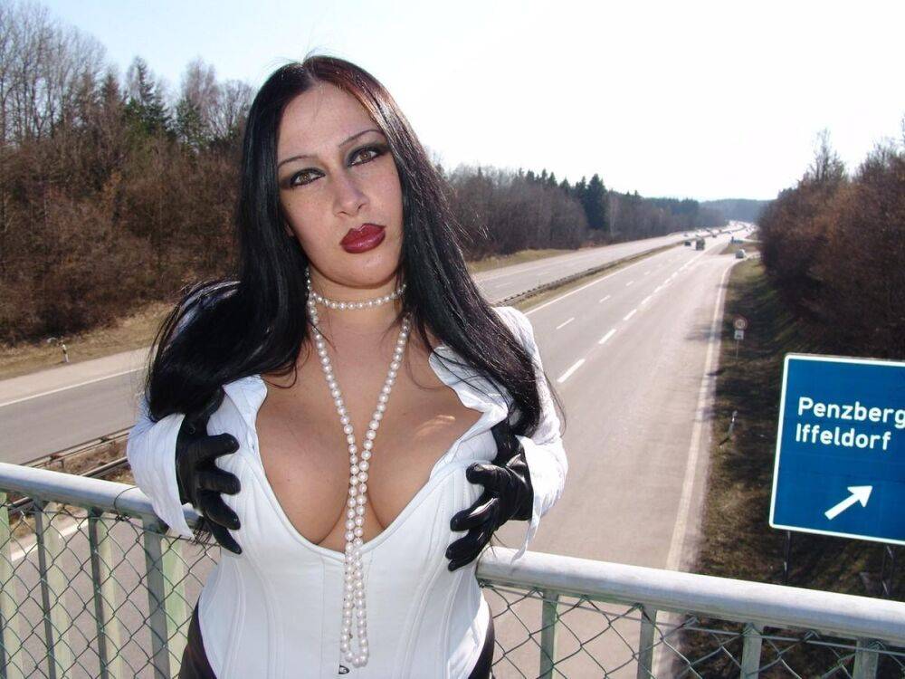 Goth model Lady Angelina poses in white latex wear & a black skirt on a bridge - #12