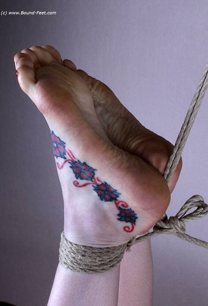 Naked white girl sports tattooed feet while suspended in midair by ropes - #14