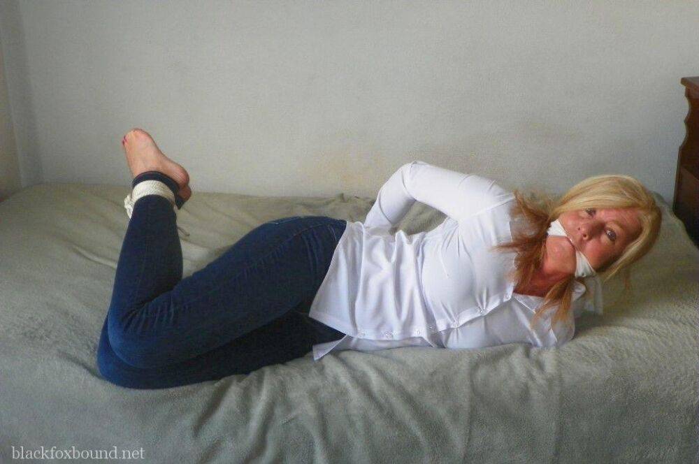 Blonde woman is cleave gagged and hogtied in a white blouse and blue jeans - #3