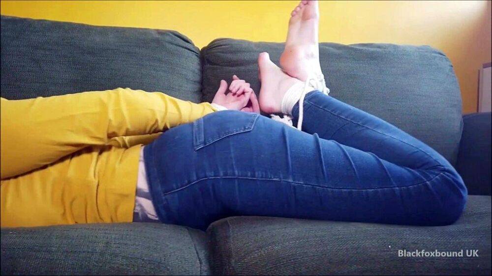 Barefoot white girl is hogtied on a sofa while ball gagged in her clothing - #8