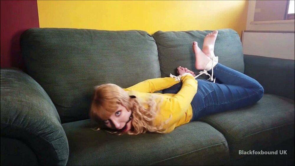 Barefoot white girl is hogtied on a sofa while ball gagged in her clothing - #6