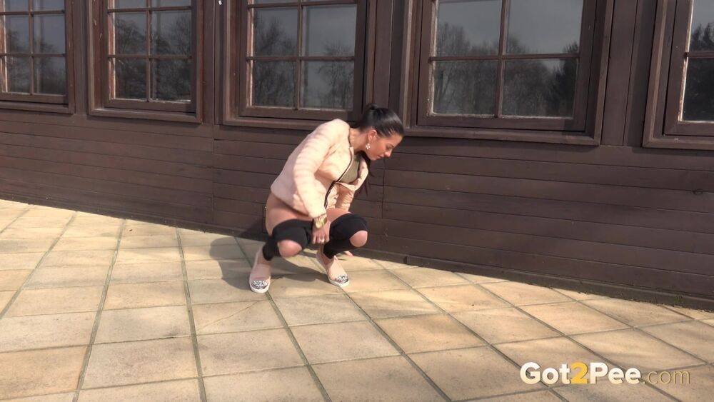 White girl squats for an urgent piss on tiled flooring outside a building - #7