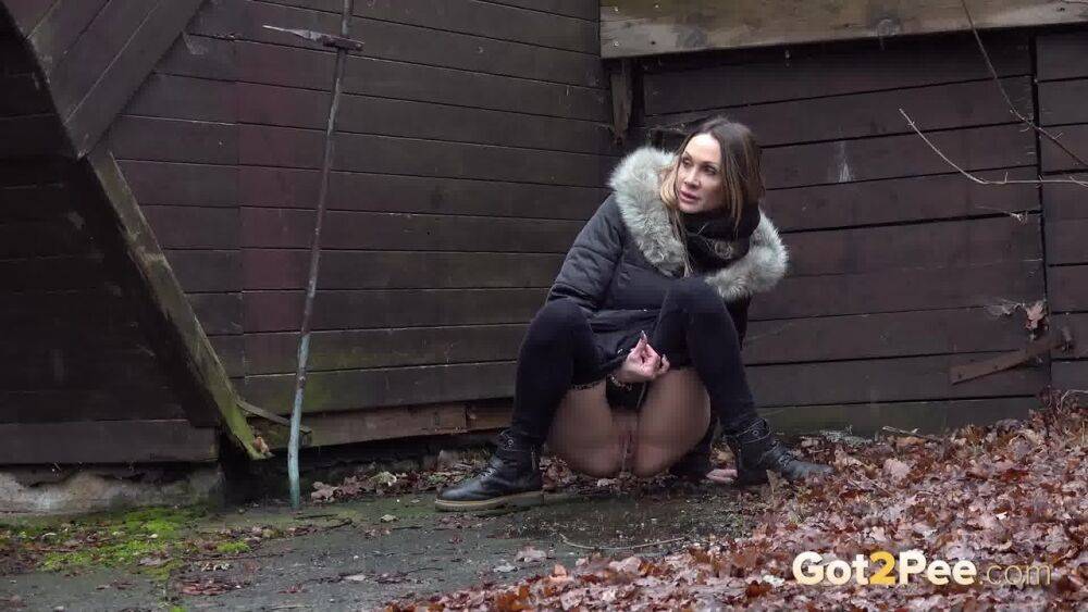 White girl Cynthia Vellons squats to take a piss next to an isolated building - #10