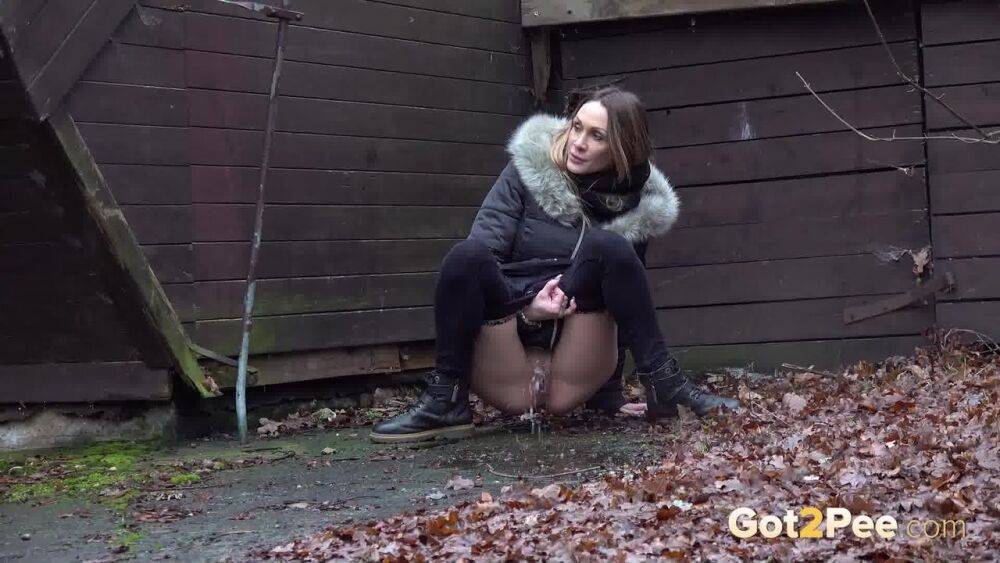 White girl Cynthia Vellons squats to take a piss next to an isolated building - #14