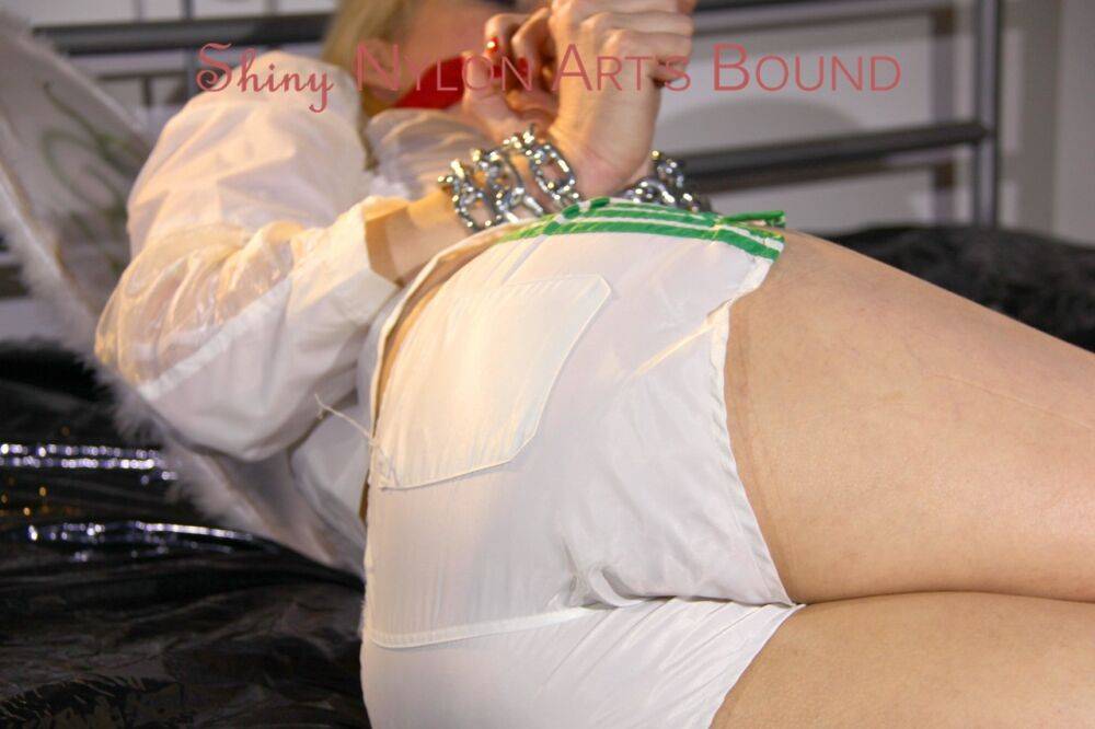 Pia tied and gagged on a bed with cuffs wearing a sexy white shiny nylon - #15