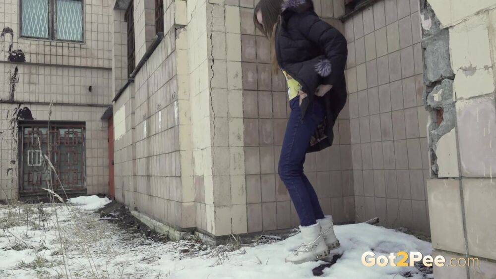 White girl Vika takes an urgent piss on snow-covered ground next to a building - #7