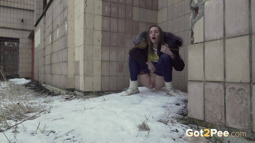 White girl Vika takes an urgent piss on snow-covered ground next to a building - #4