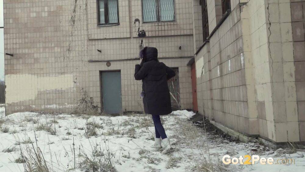 White girl Vika takes an urgent piss on snow-covered ground next to a building - #1